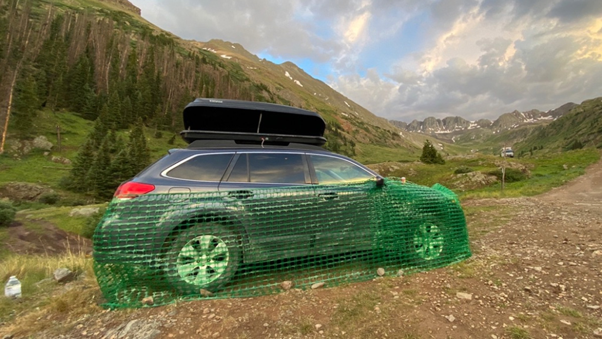 A car at American Basin in Colorado, USA using flexible plastic fencing to protect the underside of the car from critters.